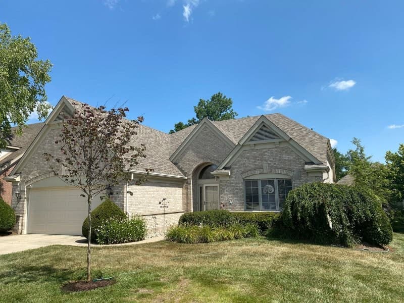 Single-story stone house with shingle roof