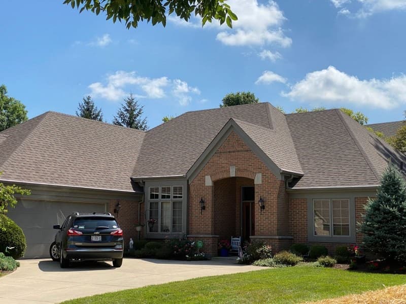 Brick ranch house with shingle roof and driveway